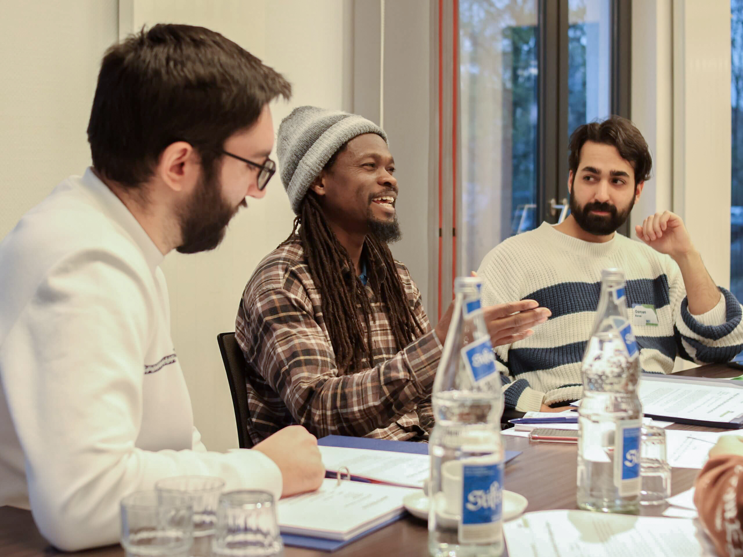 3 junge Männer in einem Workshop diskutieren ausführlich